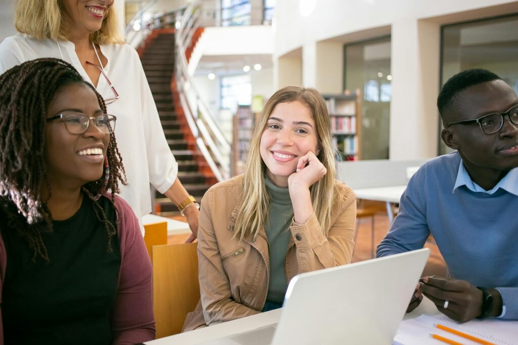 African university student smiling while researching scholarships on laptop