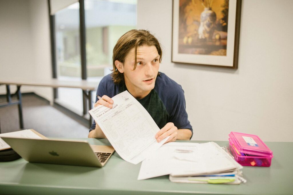 college student smiling while reviewing scholarship renewal documents at a desk