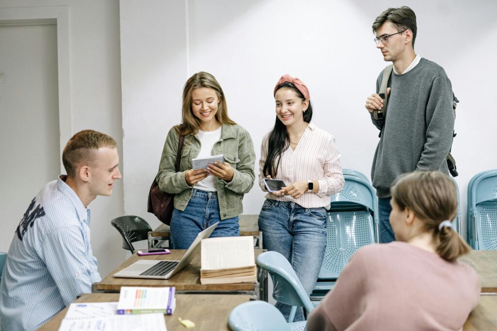 community college students studying together on campus with laptops and textbooks