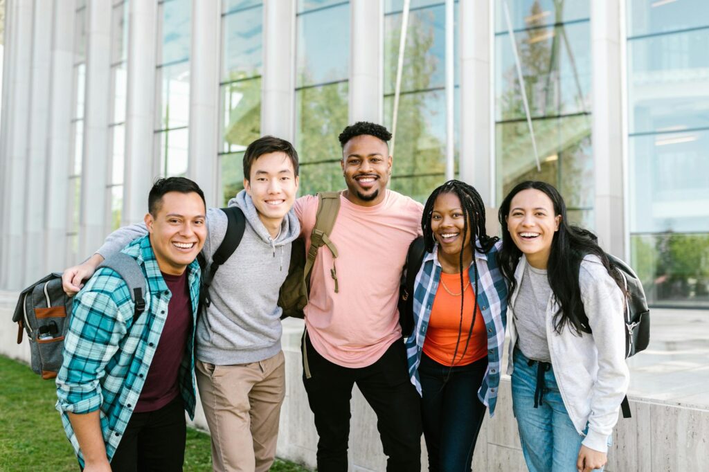 diverse college students celebrating scholarship award outdoors on a university campus
