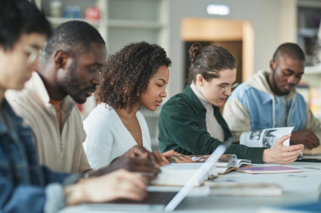 diverse group of undergraduate students studying together in university library