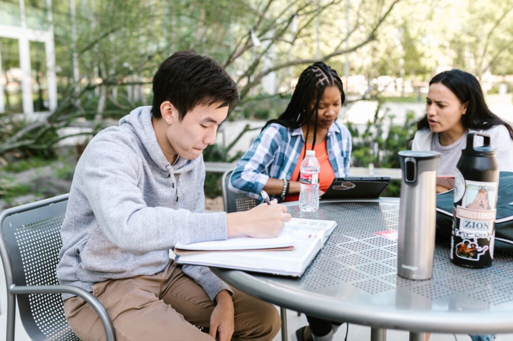 diverse group of university students collaborating on a project outdoors