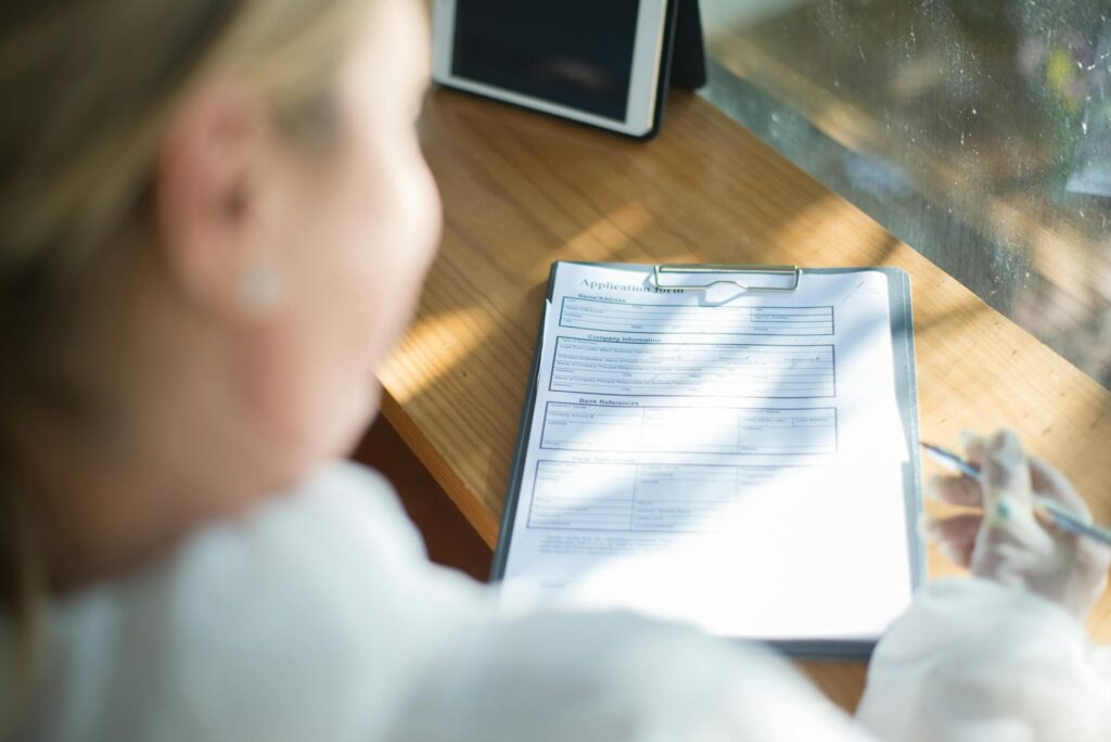 female nursing student filling out scholarship application form at desk