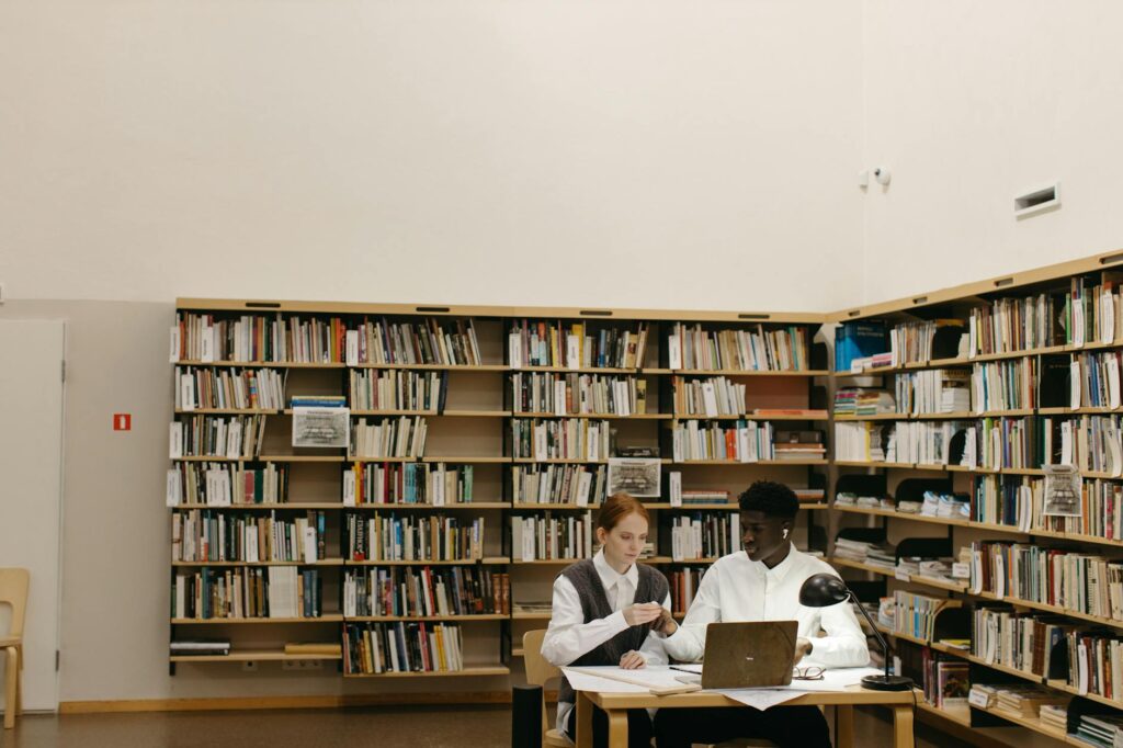 graduate student researching scholarships on laptop in university library