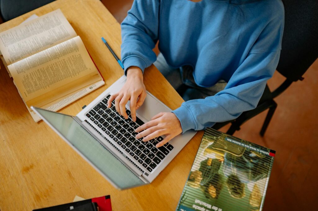 high school senior student researching scholarships on laptop at desk
