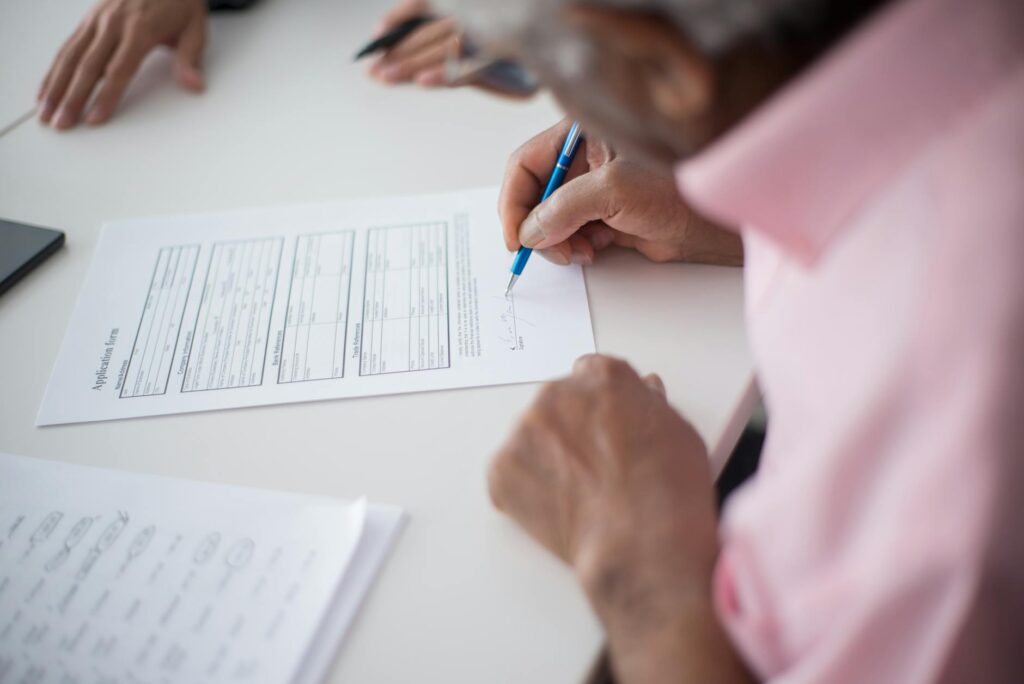 person checking eligibility requirements on a grant application form with highlighter