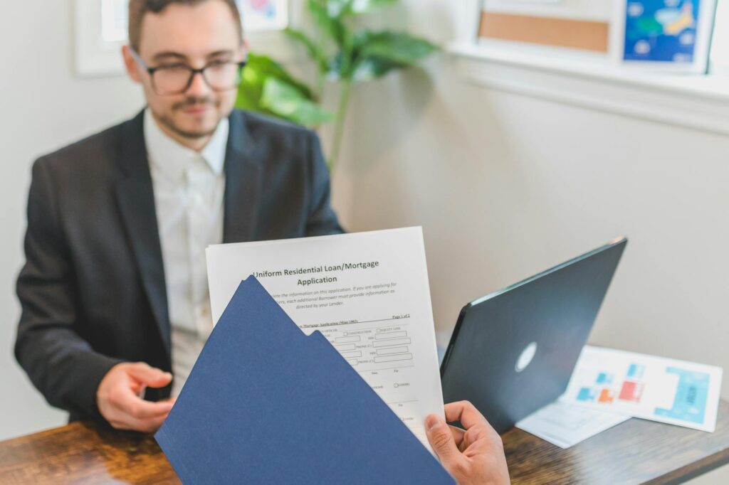 scholarship application documents and laptop on desk with financial planning notes