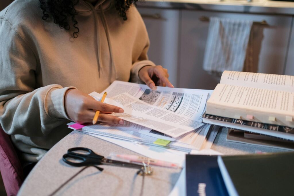 college student reviewing scholarship calendar and financial aid forms at desk