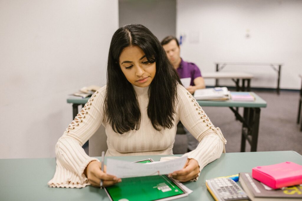college student surrounded by calendars and scholarship application papers looking focused and determined