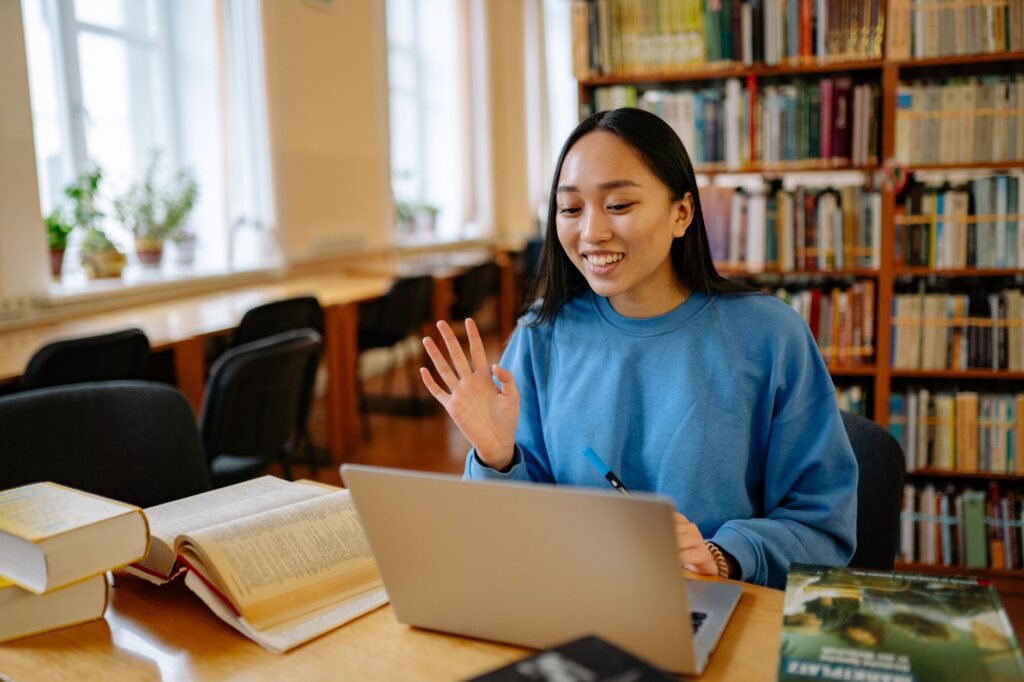 community college student smiling while filling out financial aid application on laptop