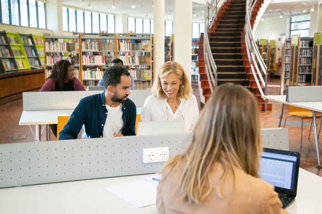 diverse community college students studying together in campus library