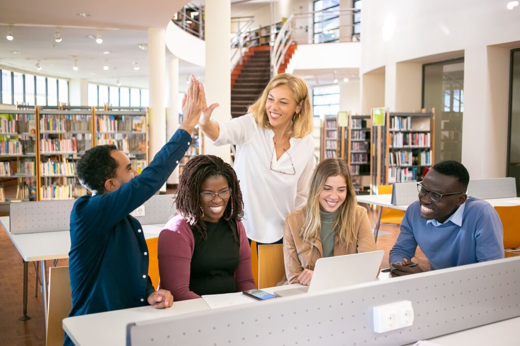 diverse group of college students reviewing financial aid documents together in a library