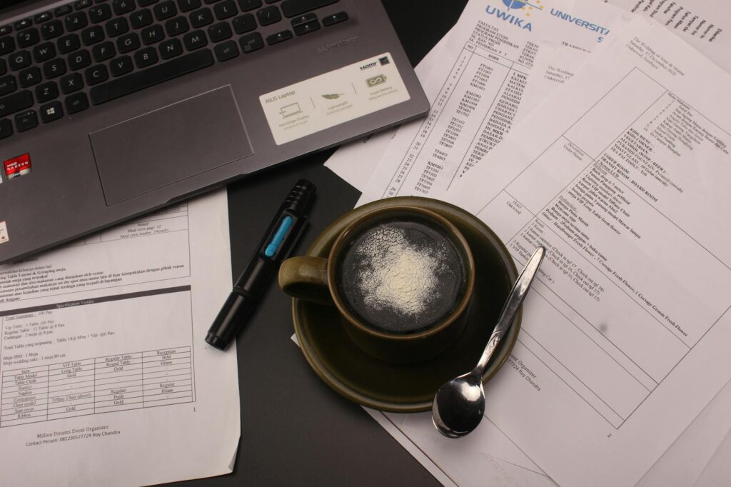 scholarship application documents and laptop on a desk with coffee
