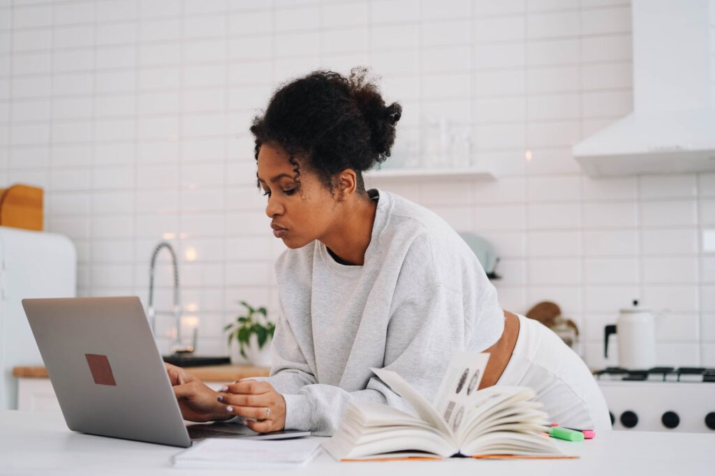 student filling out FAFSA form on laptop at home kitchen table