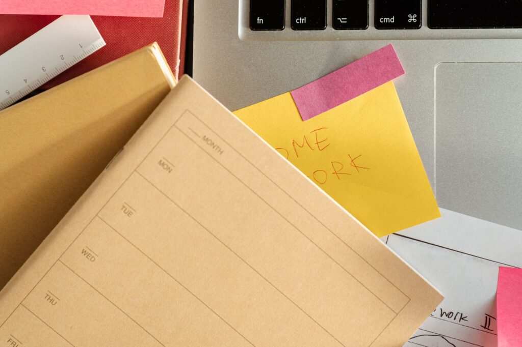 student organizing scholarship deadlines on laptop with calendar and sticky notes